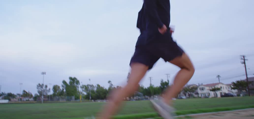 Man runs on a track near a field