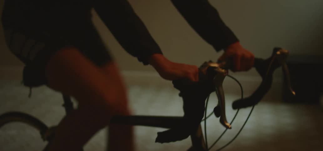 A man is riding an exercise bike indoors