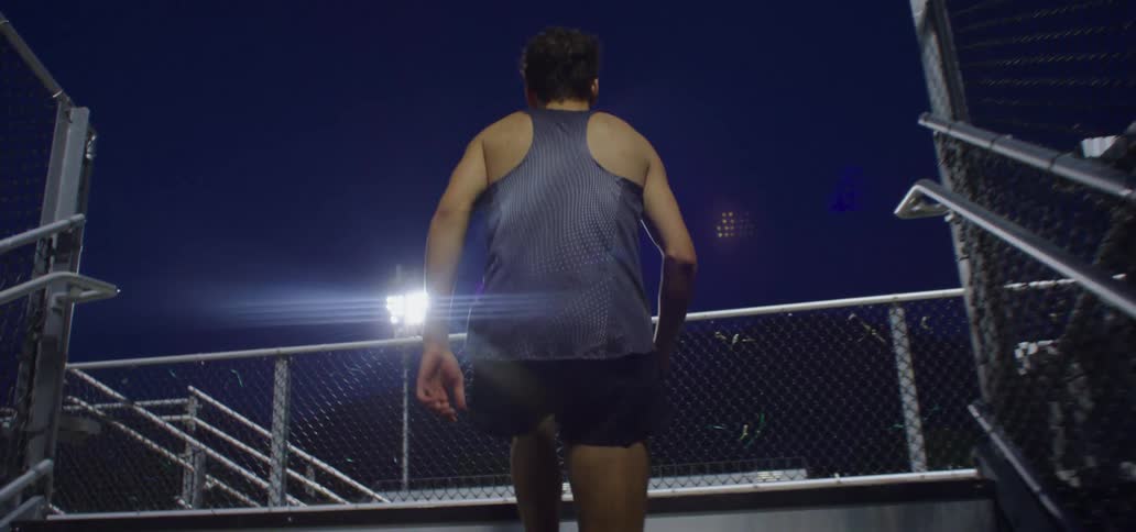 A woman who has been exercising walks up stadium stairs
