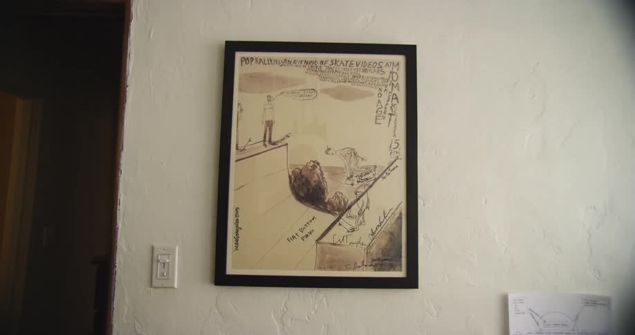A painting on a black frame hanging from a wall in a house