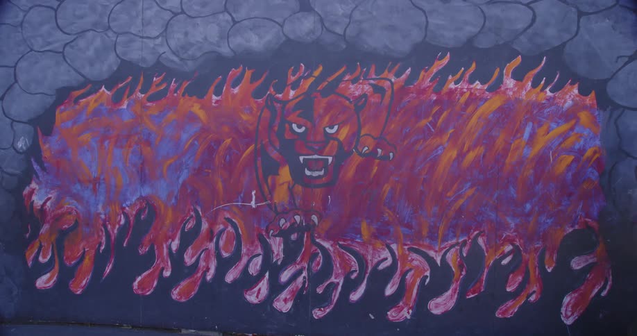 The wall has a large graffiti image on it