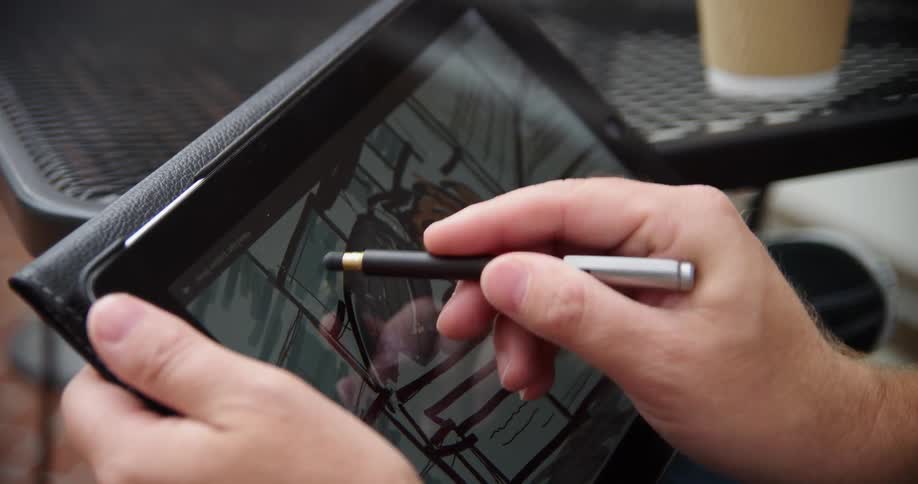 A man is sketching a picture on a tablet