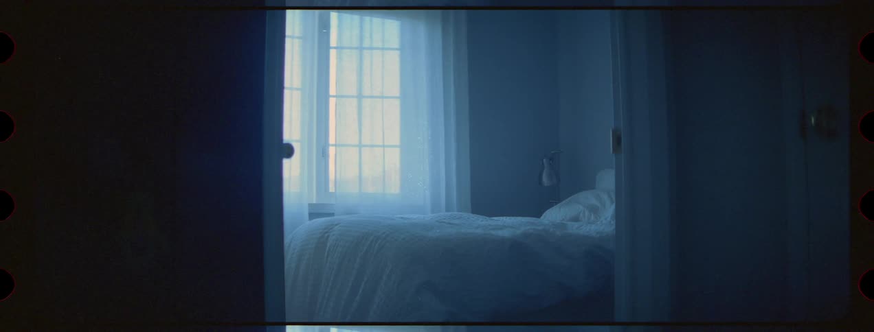 A bedroom with white curtains and comforter