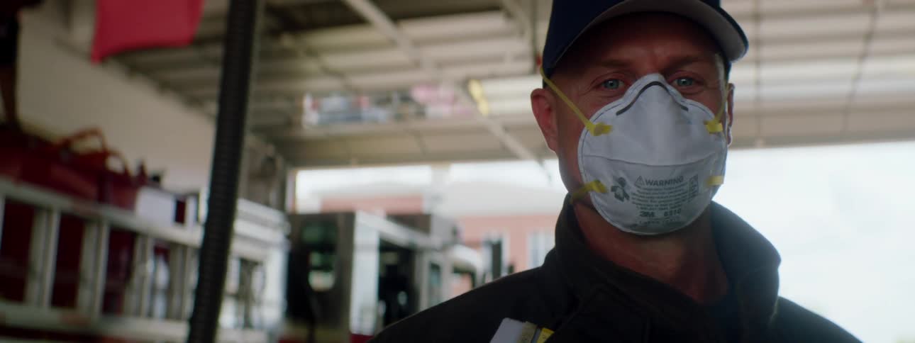 Man stands in a building wearing a medical mask