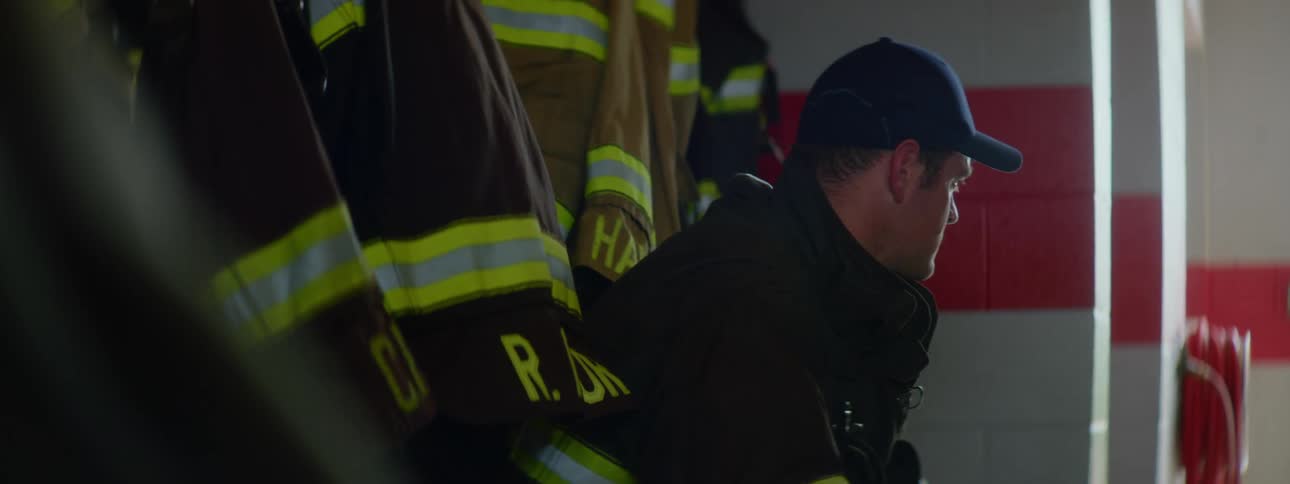 A firefighter sits along the wall in a fire station