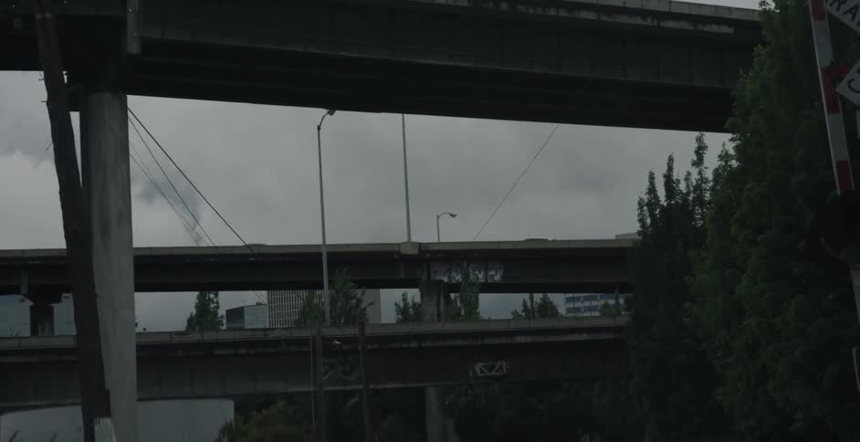 Cars drive over a bridge on a cloudy day