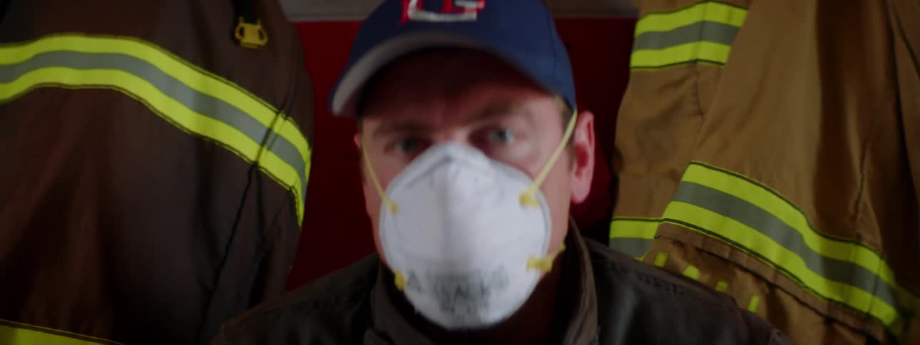A fire fighter putting a mask on