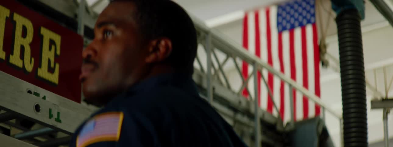 A firefighter looks at the flag in the firehall