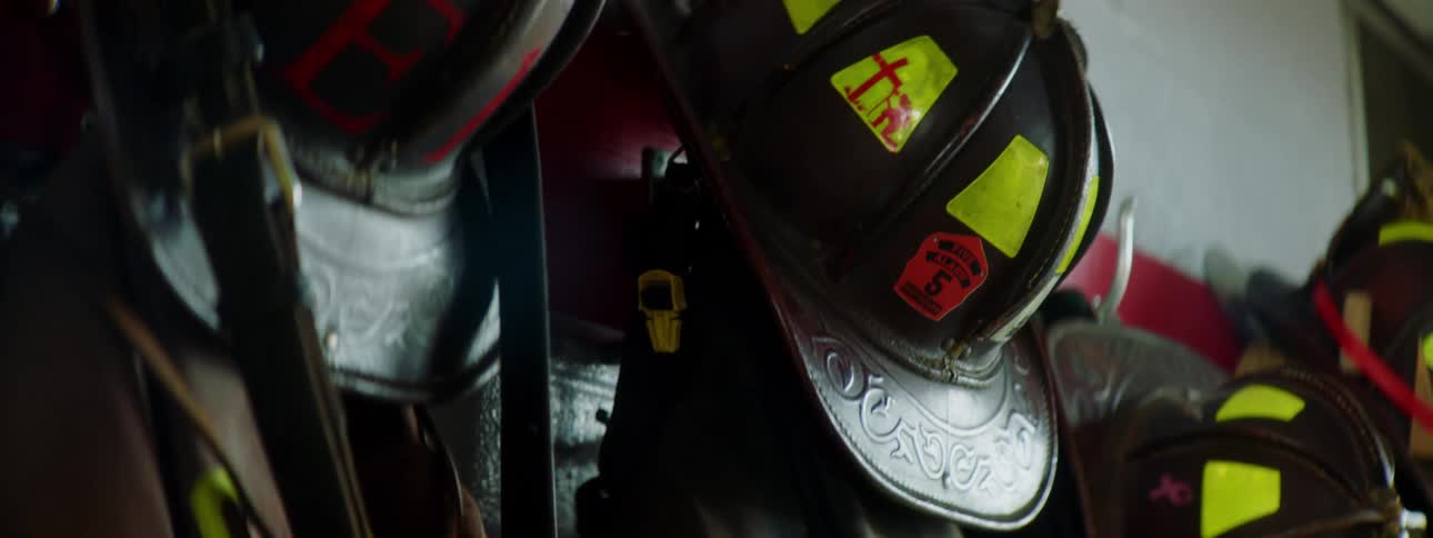 The personal protective equipment of firefighters hanging from wall hooks