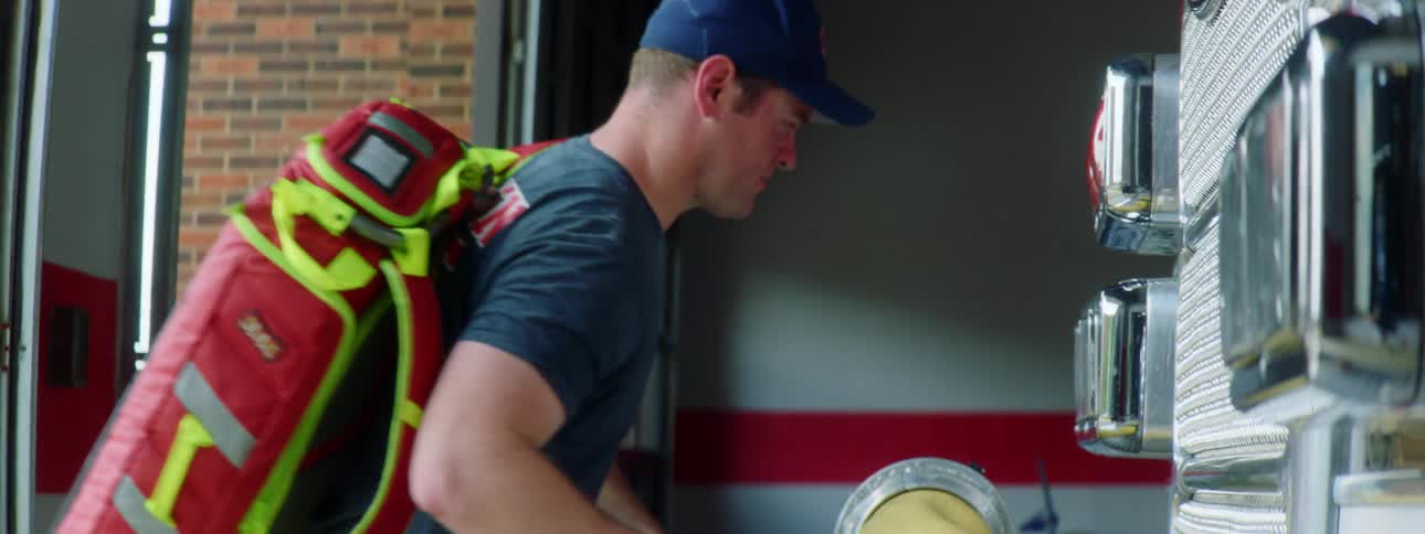 A firefighter picks up some papers as he walks in to the station