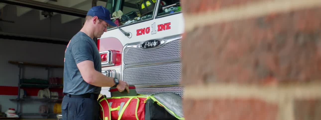 A firefighter is putting away equipment