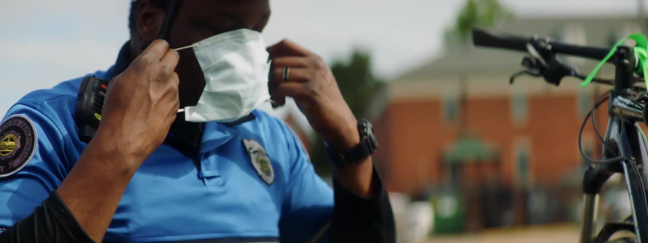 A police officer puts on his mask