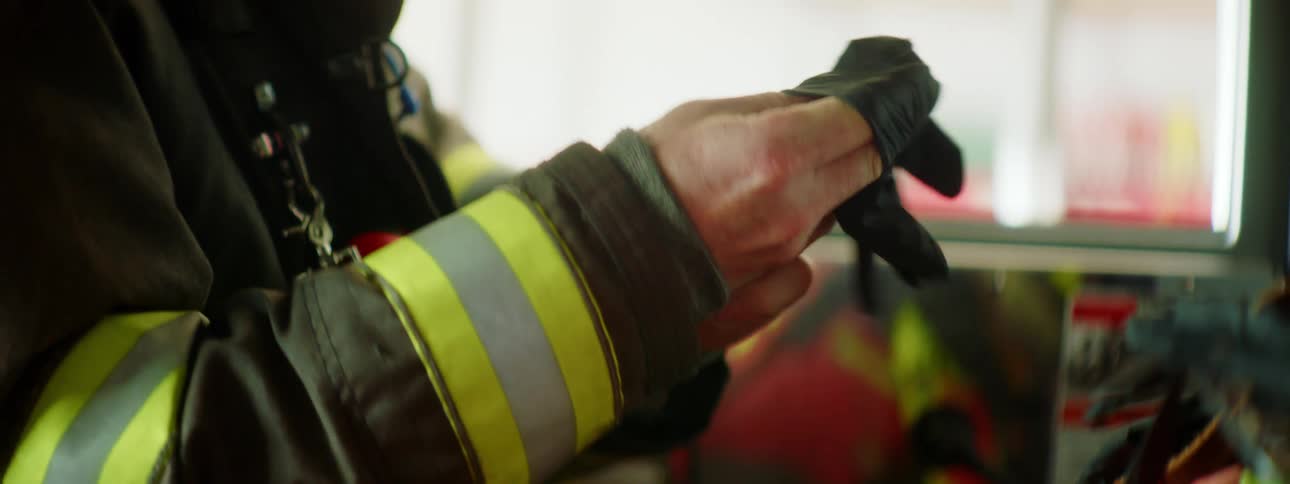A firefighter puts on his mask and gloves