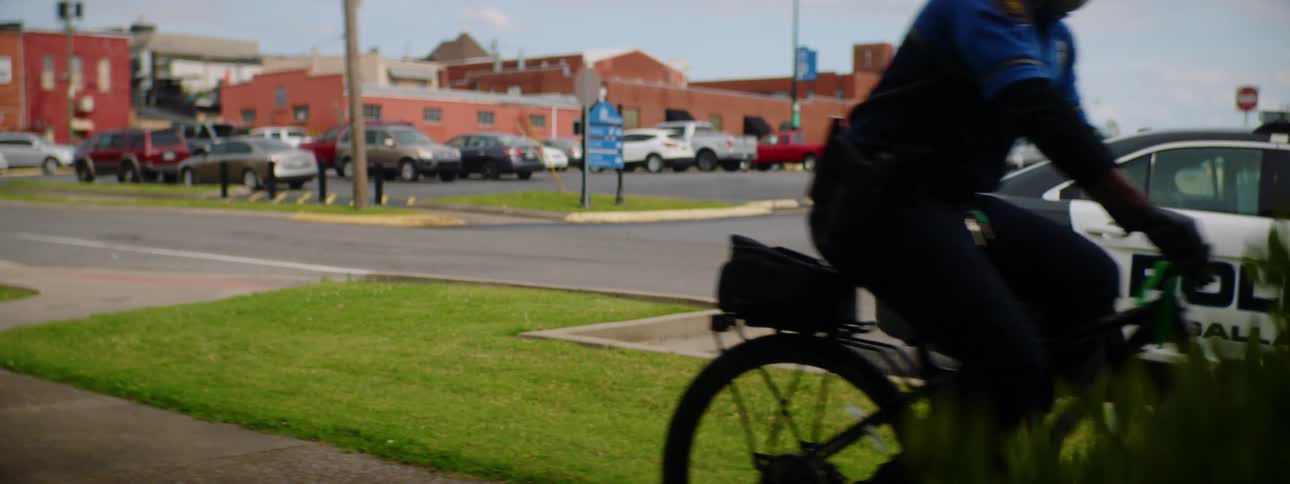 A police officer rides his bicycle onto the sidewalk