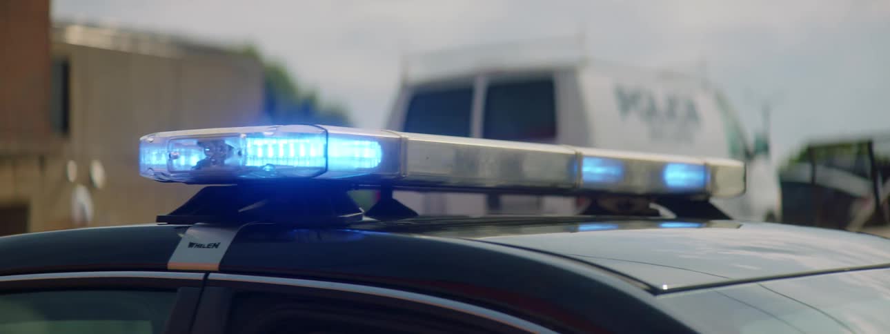Close up of police car blue roof flashing lights driving away
