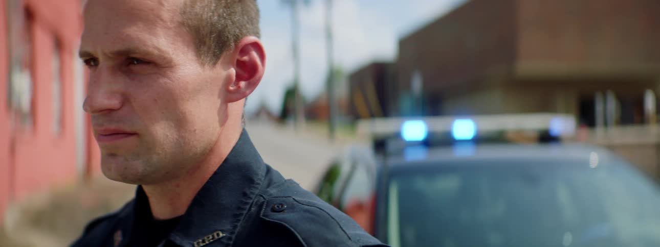 A police officer is standing by the building