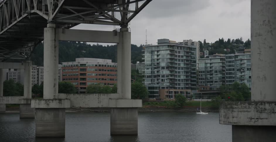 A boat is docked by the shore of a town on a cloudy day