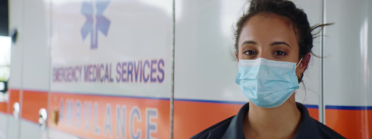 A woman stands in front of the ambulance