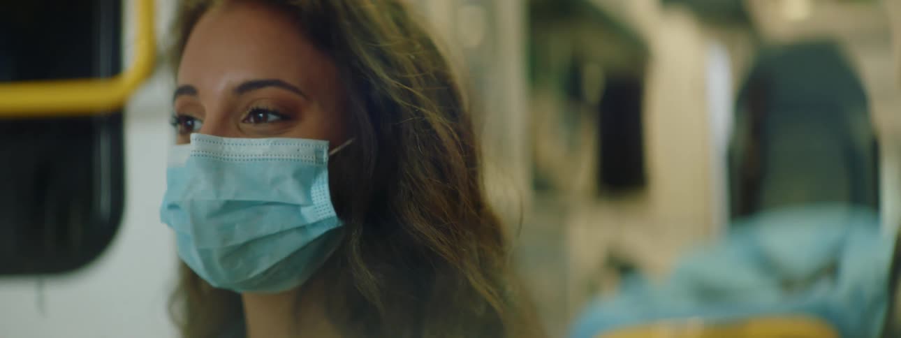A nurse stands in front of the back of an open ambulance