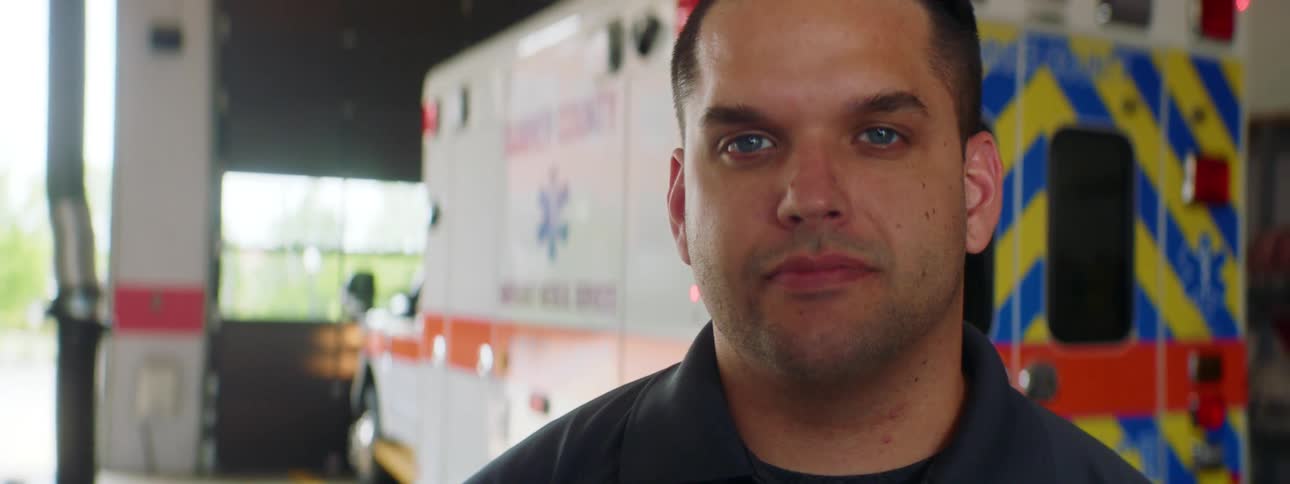 A first responder standing in front of an ambulance