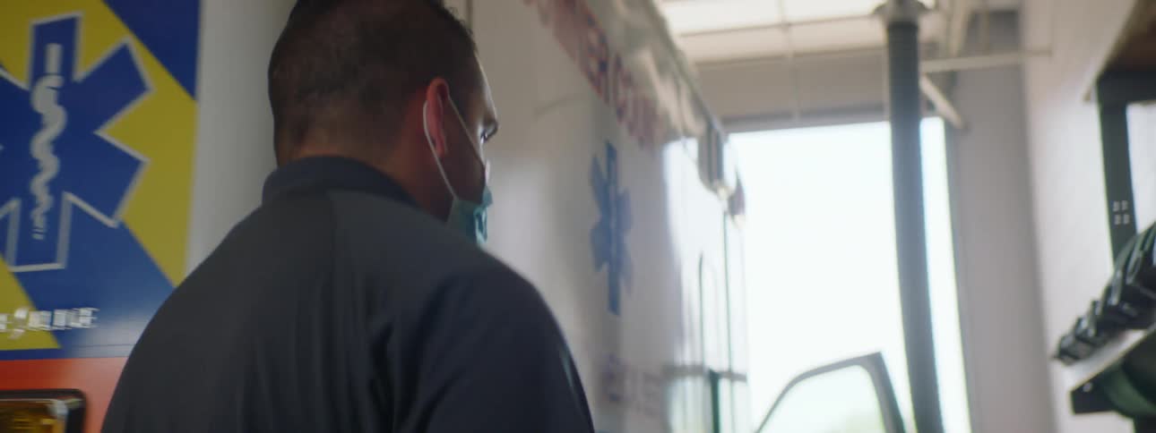 Two paramedics are closing an ambulance door