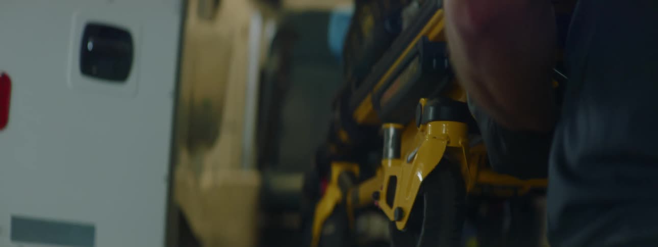 A person with gloves putting a stretcher into an ambulance