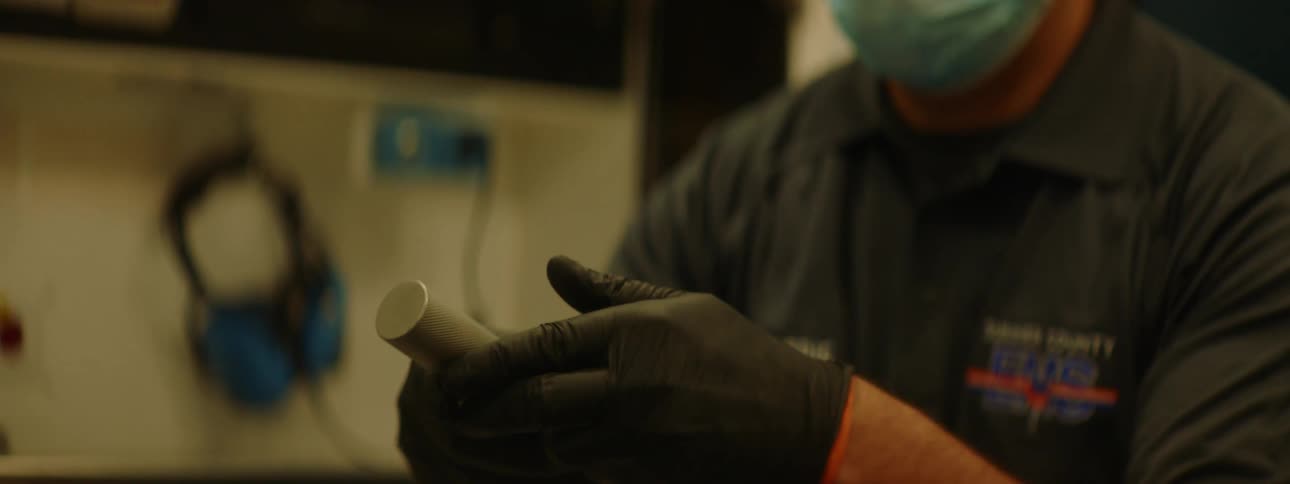 A paramedic shows a tool consisting of a curved blade and flashlight