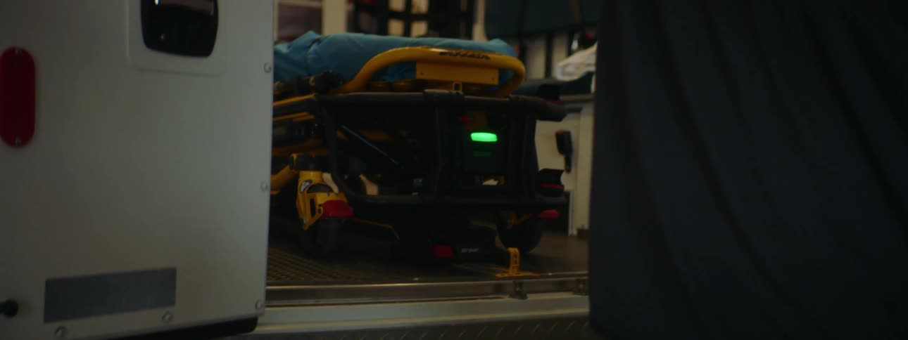 Paramedic puts stretcher inside an ambulance and closes the doors