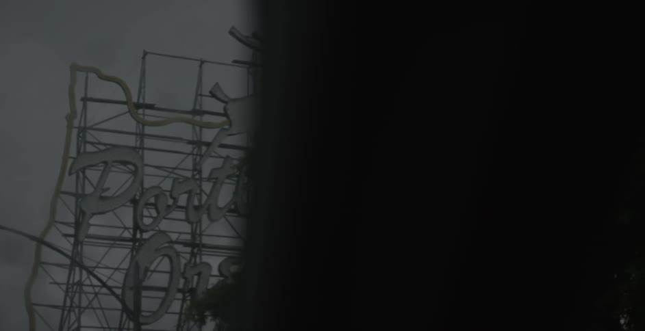Driving under a metal sign on a cloudy day