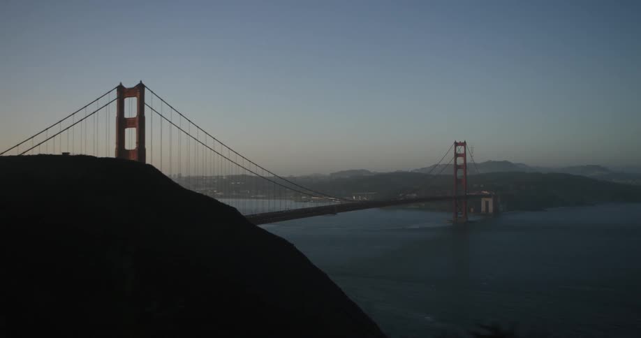 A hillside view of the golden gate bridge in the early morning