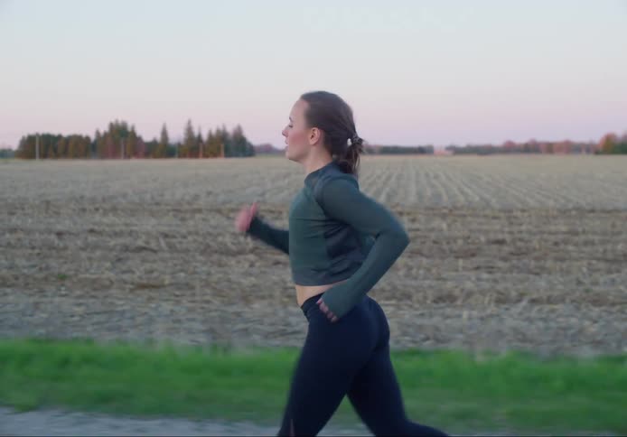 Female running along the side of a field that has been plowed for the winter
