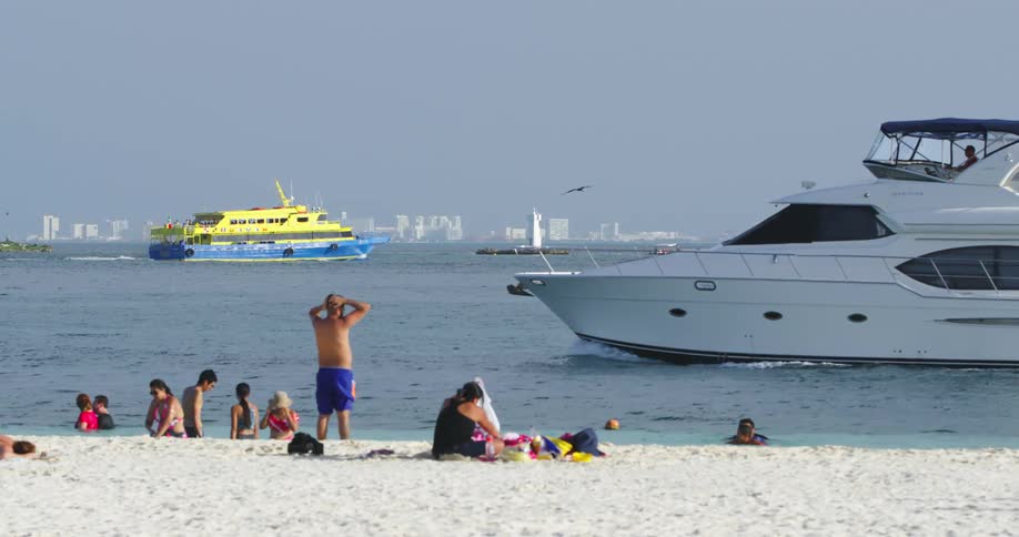 Small yacht cruising by the shoreline at the beach