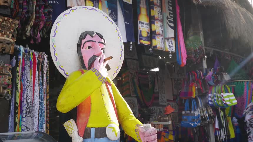 Statue of a mexican cowboy in front of a gift shop for tourists on the street of a small town