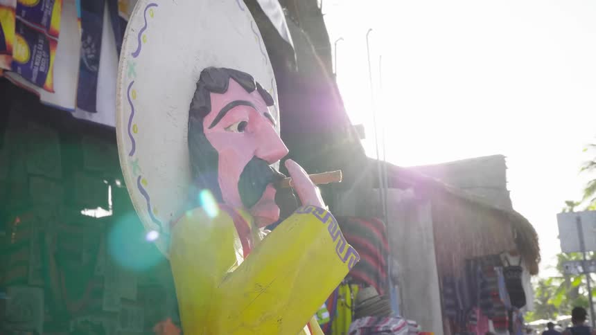 Colorful statue of a mexican with a cigar in his mouth and a sombrero