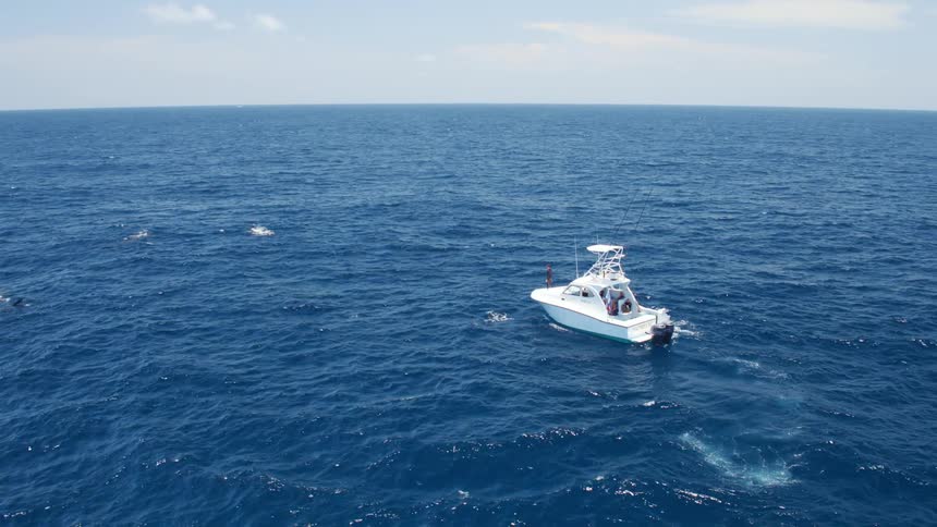 Aerial view of a small recreational yacht on the blue ocean waters