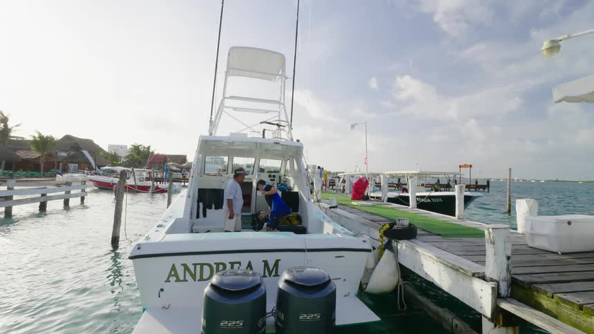 A man walks on the pier to climb on his boat