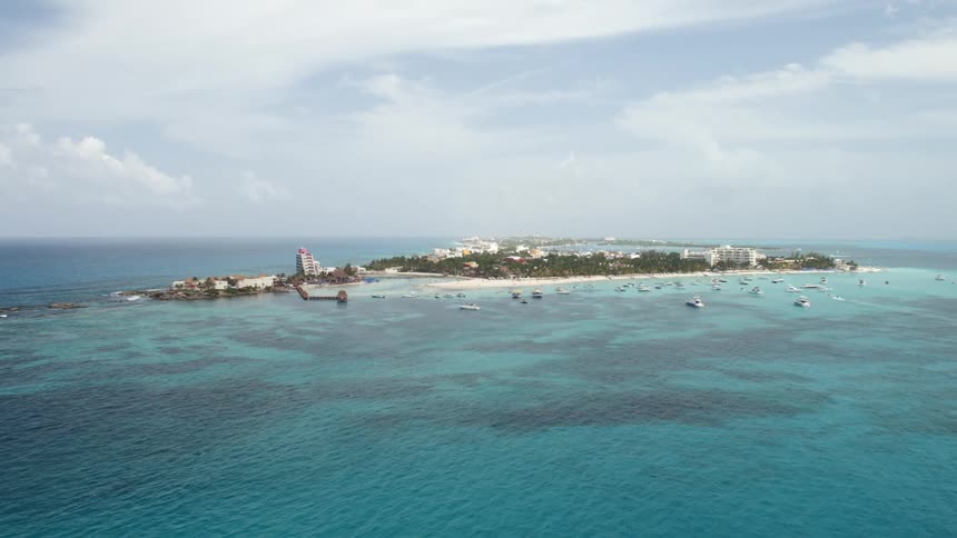 Resort town occupies crescent shaped island surrounded by azure water