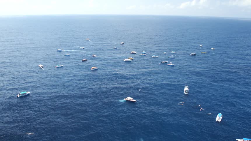 The boats travel in the ocean below