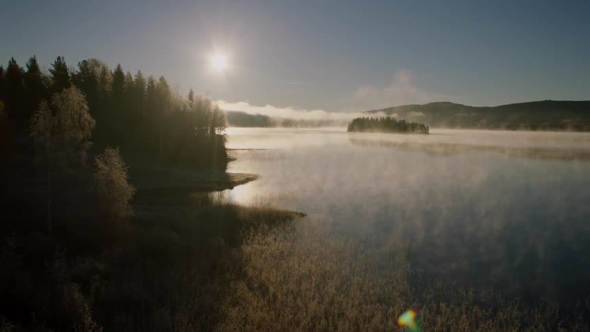 The sun shines over a mountain lake