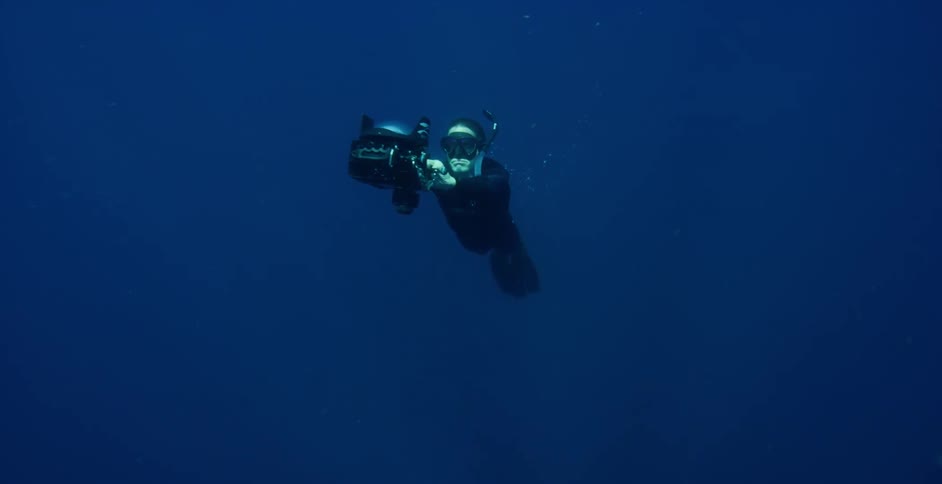 A person underwater with a snorkel flippers and a camera