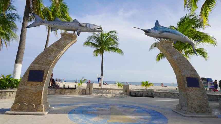A monument with fish statues is by the beach