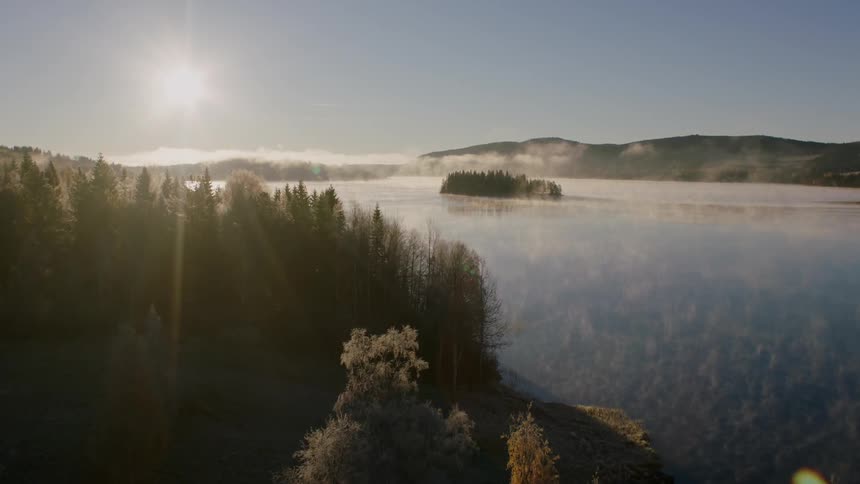 The sun shines over a mountain lake