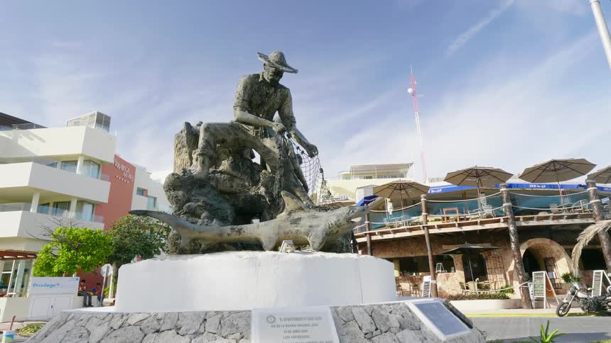 A man and woman on vacation walk past a statue