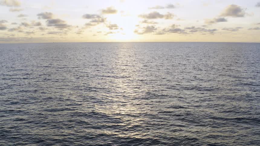 Aerial view of the sun setting over the ocean