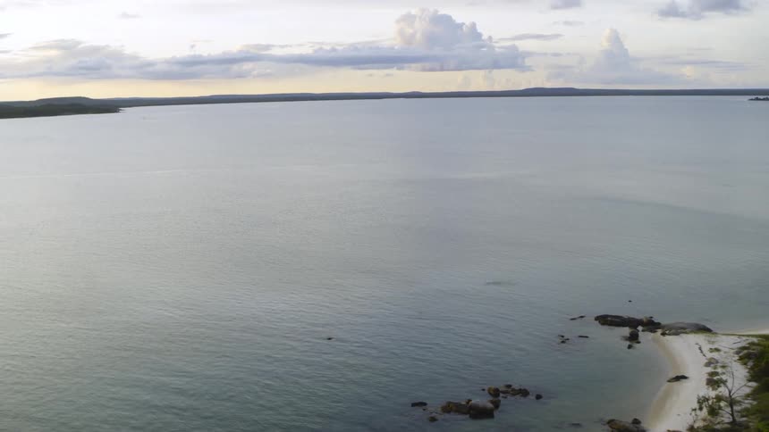 An aerial view of an ocean is displayed at dusk