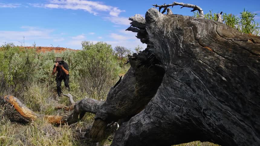A man is taking pictures in the wilderness