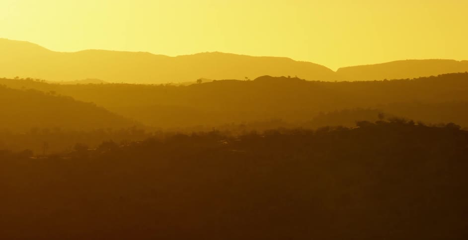 The sun sets over mountains in the wilderness
