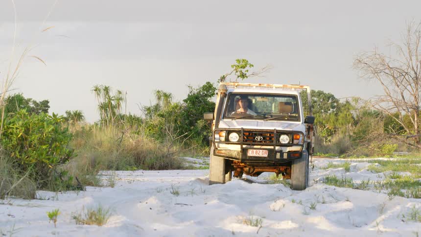 All terrain vehicle driving on the white sand near a beach