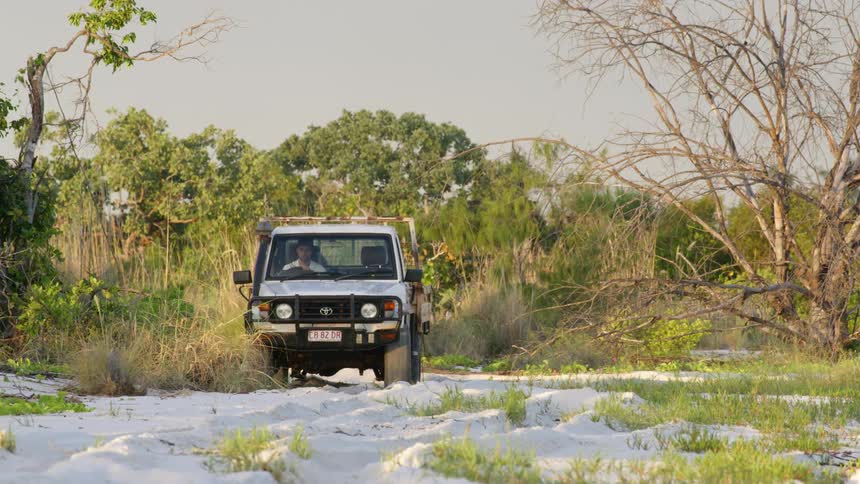A man drives his truck on the sand