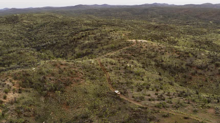 Car traveling on a dirt road over rough terrain in the wilderness